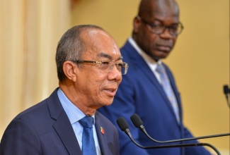 Deputy Prime Minister and Minister of National Security, Hon. Dr. Horace Chang (left), addressing Wednesday’s (November 15) post-Cabinet press briefing at Jamaica House. Listening is Deputy Commissioner of Police Fitz Bailey.