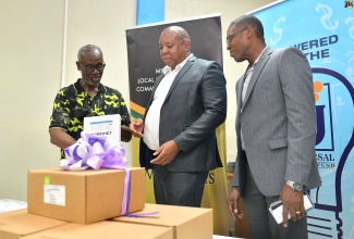 Minister of Local Government and Community Development, Hon. Desmond McKenzie (left), listens as Financial Controller, Universal Service Fund, Andrew McRae (centre), explains the features of the FortiGate Firewalls devices, at the Ministry’s offices on Hagley Park Road in Kingston on Friday (November 3).  Also listening is Department Head, Network Services, eGov Jamaica Limited, Christopher McKenzie.