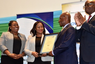 Minister of Industry, Investment and Commerce, Senator the Hon. Aubyn Hill (second right) presents a certificate to Chief Executive Officer of the Cannabis Licensing Authority, Farrah Blake, during the National Certification Body of Jamaica (NCBJ)World Quality Week Certificate Handover Ceremony at The Jamaica Pegasus hotel in New Kingston on November 9. Sharing the moment (from left) are Manager, NCBJ, Navenia Wellington Ford and Executive Director of the Bureau of Standards Jamaica, Dr. Velton Gooden.