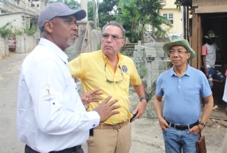 Minister of Science, Energy, Telecommunications and Transport, Hon. Daryl Vaz (centre), and Deputy Prime Minister and Minister of National Security and Member of Parliament for St. James North Western, Hon. Dr. Horace Chang (right), converses with Managing Director, Jamaica Social Investment Fund (JSIF), Omar Sweeney, during a tour of underserved communities in St James on Friday (November 10) to identify areas requiring urgent attention under the Rural Electrification Programme (REP).