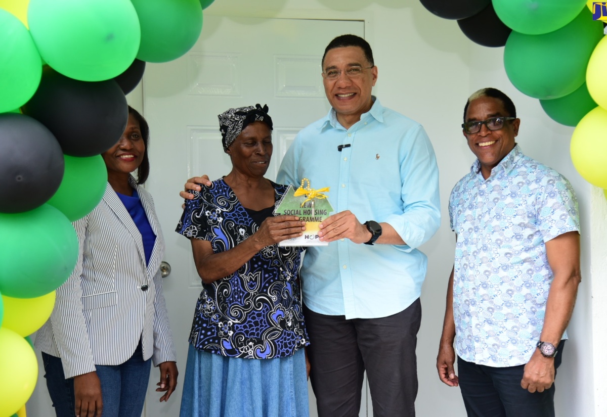 Prime Minister the Most. Hon. Andrew Holness (second right), gives the keys to beneficiary of a one-bedroom unit under the New Social Housing Programme (NSHP) in Belfield, St. Mary, Susettee Hudson, at the official handover of the house on December 21. Looking on (from left) are Permanent Secretary in the Ministry of Economic Growth and Job Creation, Arlene Williams and Member of Parliament for St. Mary, South Eastern, Dr. the Hon. Norman Dunn.