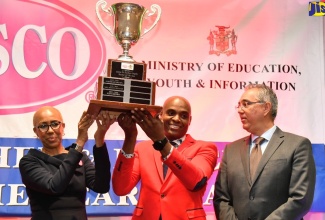 Minister of Education and Youth, Hon. Fayval Williams (left), presents the LASCO/Ministry of Education and Youth/Jamaica Teaching Council 2023 Teacher of the Year trophy to St. Andrew High School for Girls Chemistry teacher, Franklin Burrell (centre), during Tuesday's (December 5) awards ceremony, held at The Jamaica Pegasus hotel in New Kingston. Sharing in the presentation is Managing Director at LASCO Distributors Limited, John De Silva.

 