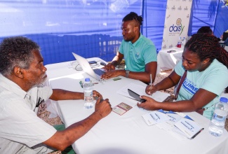 Senior citizen from Linstead, Utol Warrel (left), looks on while Health Records Clerk, South East Regional Health Authority (SERHA), Heather Francis (right), completes the registration process, during the Ministry of Health and Wellness’ ‘Know Your Numbers’ campaign event held recently in the St. Catherine community. At centre, Methods Development Executive at the Ministry, Travis Clarke, enters data in a computer. The Know Your Numbers campaign aims to encourage yearly health screening to reduce illness among the population. Services offered included blood pressure, blood sugar, cholesterol, and body mass index (BMI) checks; HIV and Prostate Specific Antigen (PSA) tests; Digital Rectal Exam (DRE) and pap smear. Patrons attending the all-day event also received dental checks.

