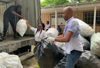 Photo # 03: Member of Parliament for Hanover West, Tamika Davis (centre), joins WPM Waste Management Limited’s crew in collecting bulk and plastic waste in a Hanover community recently. The WPM team was led by regional operations manager, Edward Muir (right).


