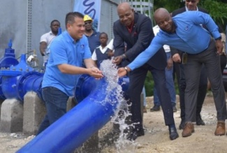 Minister without Portfolio in the Ministry of Economic Growth and Job Creation, Senator the Hon. Matthew Samuda (left); Minister of Tourism and Member of Parliament for East Central St. James, Hon. Edmund Bartlett (centre) and Acting Vice President of Operations at the National Water Commission (NWC), Herman Fagan (right) wash their hands, following the official commissioning of the Cedar Hill Tank and Somerton Water Supply Project on December 14. Also taking part is (background right) Councillor for the Somerton Division,  Mark McGann.