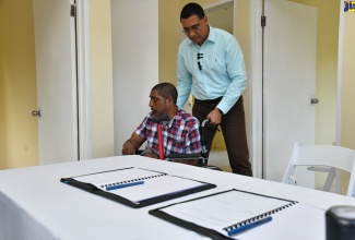 Prime Minister, the Most Hon. Andrew Holness, assists New Social Housing Programme (NSHP) beneficiary, Winston Williams, during the handover of a three-bedroom unit in Cameron Hill District in St. Elizabeth on Friday (January 12). 