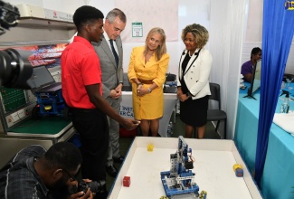 Minister without portfolio in the Office of the Prime Minister with responsibility for Skills and Digital Transformation, Senator Dr. the Hon. Dana Morris Dixon (right), listens as HEART/NSTA Trust student and WorldSkills Robotics Competition competitor, Duvanie Vassell (left), explains the robotic creation on display during the Forum for Innovations in Teaching held at the National Arena on Thursday (January 25). Others (from second left) are Director for Latin America, the Caribbean and relations with all Overseas Countries and Territories at the European Commission’s Directorate-General for International Partnerships, Félix Fernández-Shaw, and Head of the European Union (EU) Delegation to Jamaica, Ambassador Marianne Van Steen.

