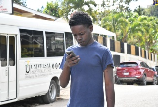 A youngster uses his smart phone to access free internet service provided under the Government’s Community Wi-Fi Programme.