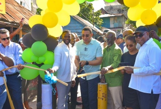 Prime Minister, the Most. Hon. Andrew Holness (third left), cuts the ribbon to officially open the rehabilitated Gravel Lane  in Montego Bay, St. James, on Monday (January 8). Also participating are (from left) Minister of State in the Office of the Prime Minister (Western Region), Hon. Homer Davis; Deputy Mayor of Montego Bay, Councillor Richard Vernon; Minister of Local Government and Community Development, Hon. Desmond McKenzie;  Minister of Legal and Constitutional Affairs, Hon. Marlene Malahoo Forte and Minister of Tourism, Hon. Edmund Bartlett. 