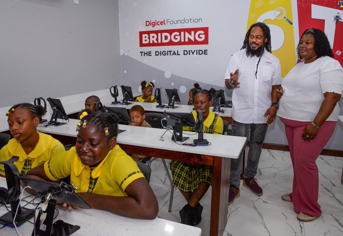 Grade-four teacher at the Homestead Primary and Infant School in St. Catherine, Shauna-Kaye Dehaney (right), in discussion with Social Development Consultant with the Digicel Foundation, Miguel “Steppa” Williams (left), during the recent handover of the new US$60,000 smart room, sponsored by the Foundation.