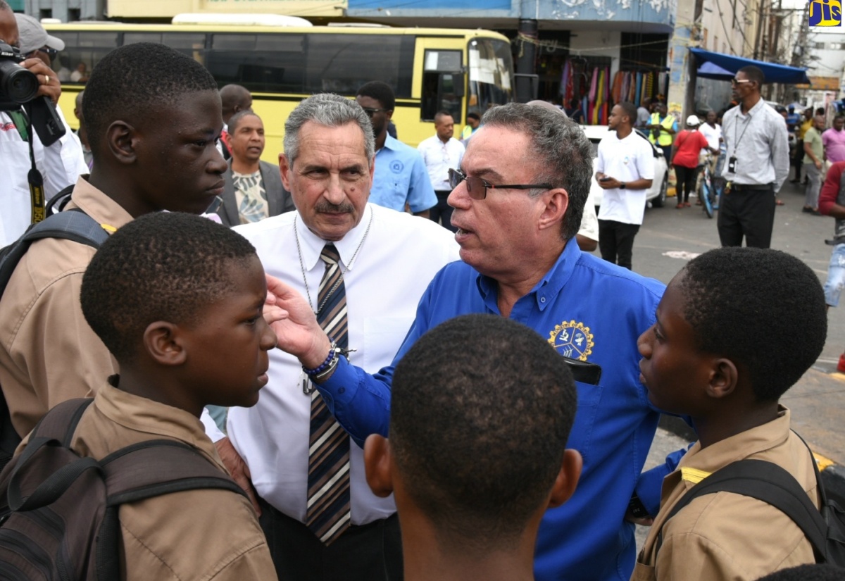 Minister of Science, Energy, Telecommunications and Transport, Hon. Daryl Vaz (second right), speaks with several students during a tour and assessment of the bus bays located at North and South Parade in downtown Kingston on Thursday (January 18). With him is Jamaica Urban Transit Company (JUTC) Managing Director, Paul Abrahams.

