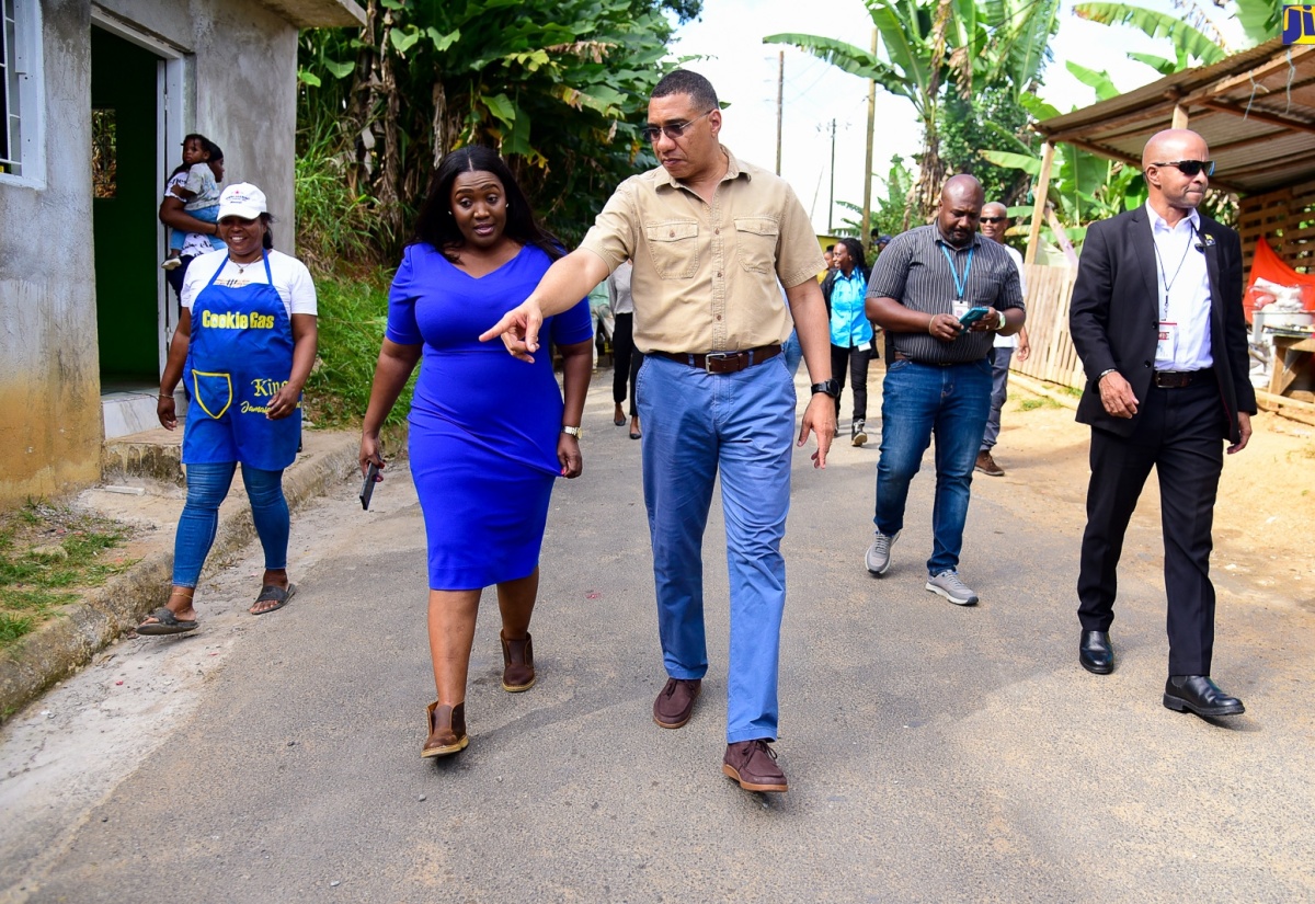 Prime Minister, the Most Hon. Andrew Hollness (right), points to a section of the recently paved Moreland community road in St. Catherine North Eastern while touring the thoroughfare on January 18.  With the Prime Minister is Member of Parliament for the area, Kerensia Morrison.

