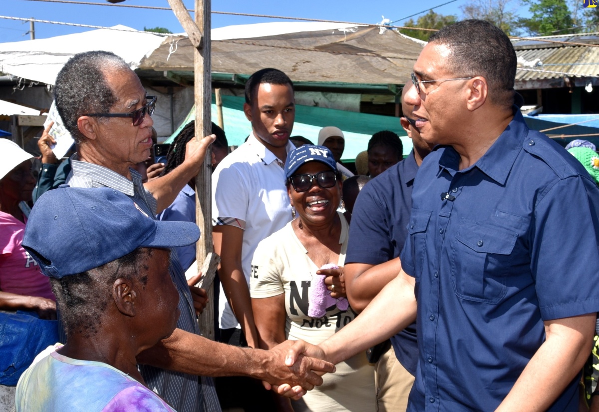 Prime Minister, the Most Hon. Andrew Holness (right), shakes hands with Barrington Fernandez (second left), during a visit to the Cleveland Stanhope Market in Lucea, Hanover on Friday (January 19). The stop at the market was part of a working visit to the parish by the Prime Minister, who was accompanied by Minister of Local Government and Community Development, Hon. Desmond McKenzie.