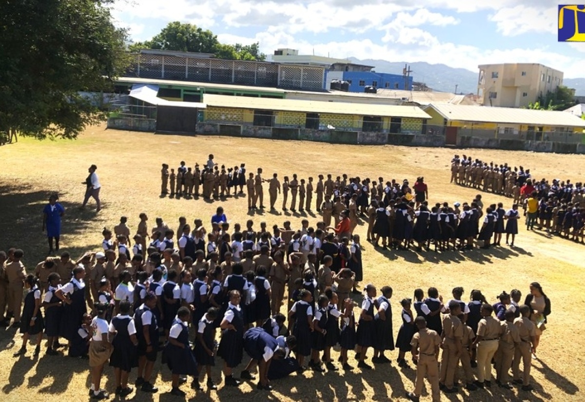 Barracks Road Primary School students gather at the designated assembly point on the playfield during the earthquake sensitisation drill that formed part of their Earthquake Awareness Month activities.

