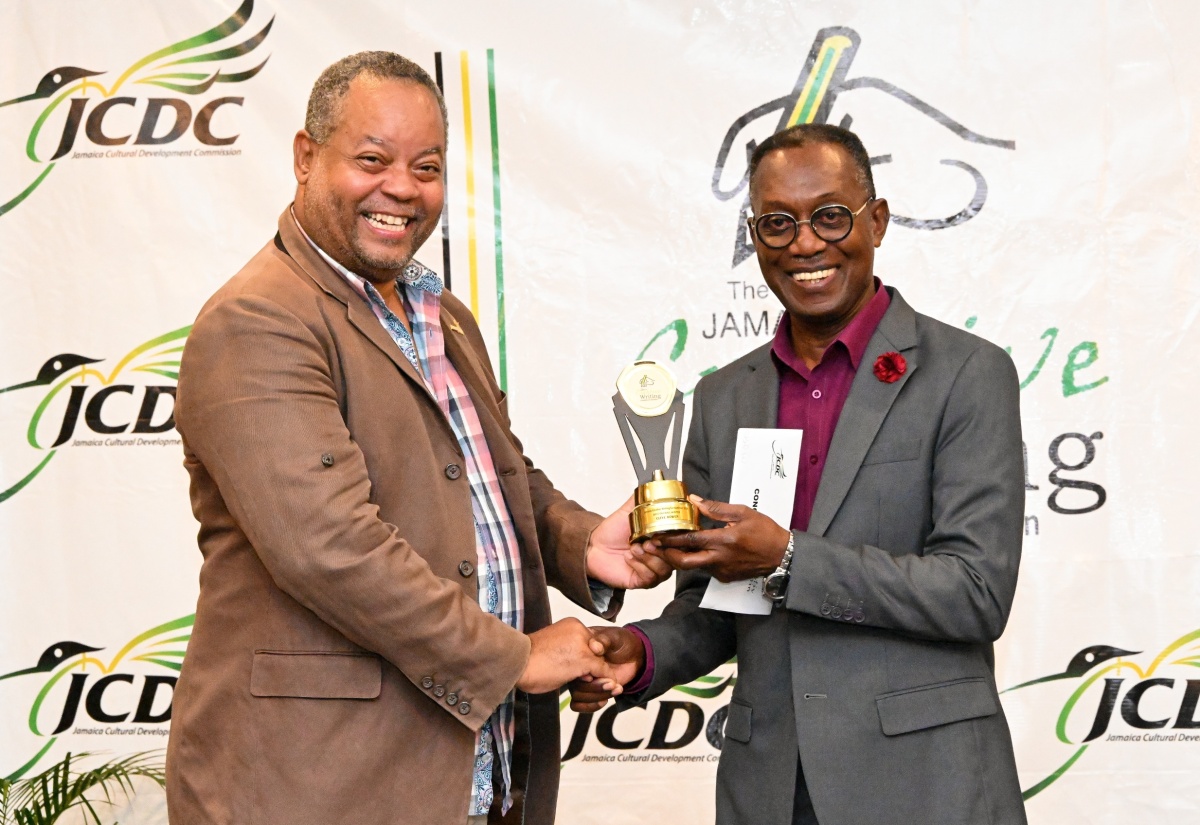 Director of Arts Development and Training at the Jamaica Cultural Development Commission (JCDC), Andrew Brodber (left), presents a trophy and cash award to the Overall Best Writer in the 2023 Jamaica Creative Writing Competition, Clyde Bowen, at a recent awards ceremony and launch of the Jamaica Creative Writing Exhibition, at the Summit in Kingston.

