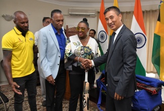 Culture, Gender, Entertainment and Sport Minister, Hon. Olivia Grange (third left) and Indian High Commissioner to Jamaica, His Excellency Rungsung Masakui (right), shake hands during the handover of 90 sets of cricket kits by the Government of the Republic of India to the Jamaica Cricket Association (JCA) on January 4, at the Indian High Commission in Kingston. Also at the presentation (from left) are Captain of the Jamaica Cricket Team, Jermaine Blackwood, and President of the Jamaica Cricket Association (JCA), Billy Heaven.

