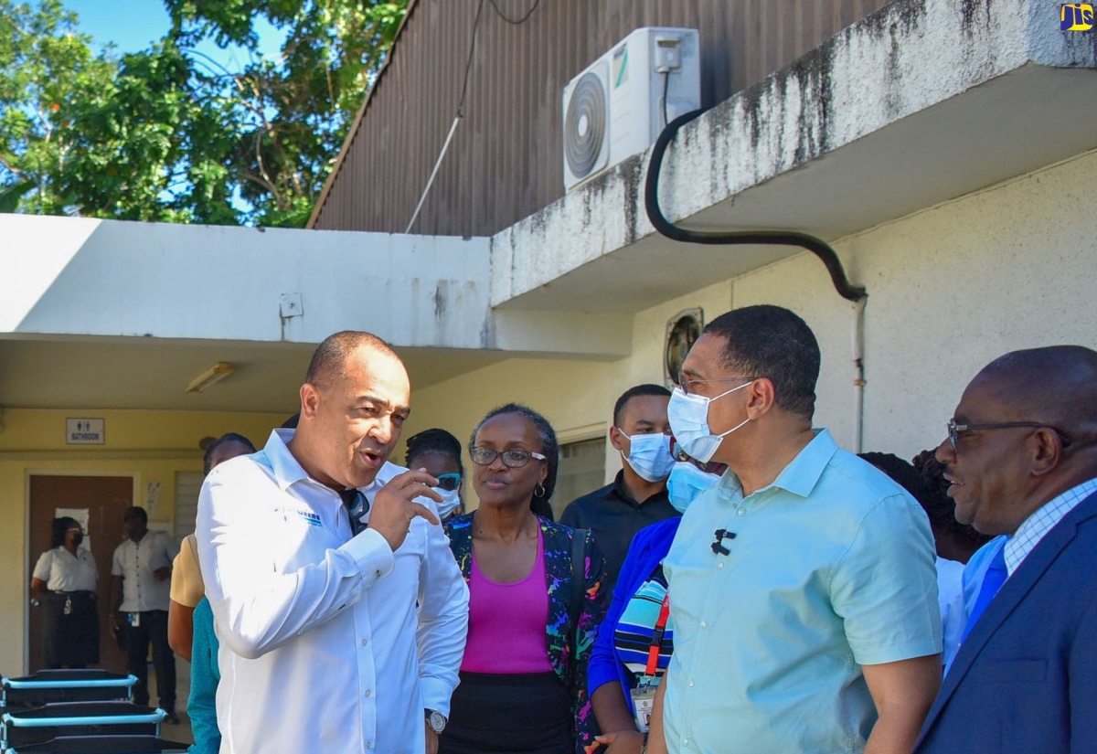 Prime Minister, the Most Hon. Andrew Holness (second from right), is briefed by Minister of Health and Wellness, Dr. the Hon. Christopher Tufton (left, foreground), on plans for the Type V Montego Bay Comprehensive Health Centre in St. James, during a tour of the facility on Monday (January 8). Looking on is St James Health Services Parish Manager, Lennox Wallace (right) and Minister of Local Government and Community Development, Hon. Desmond McKenzie (left). 
