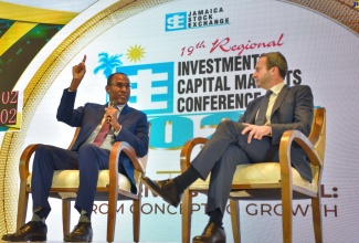 Minister of Finance and the Public Service, Dr. the Hon. Nigel Clarke (left), responds to a question at today’s (January 24) session of the Jamaica Stock Exchange (JSE) Investments and Capital Markets Conference at The Jamaica Pegasus hotel in New Kingston. At right is Head of Latin America Debt Capital Markets and Private Credit, Jefferies, Gabriel Roitman.