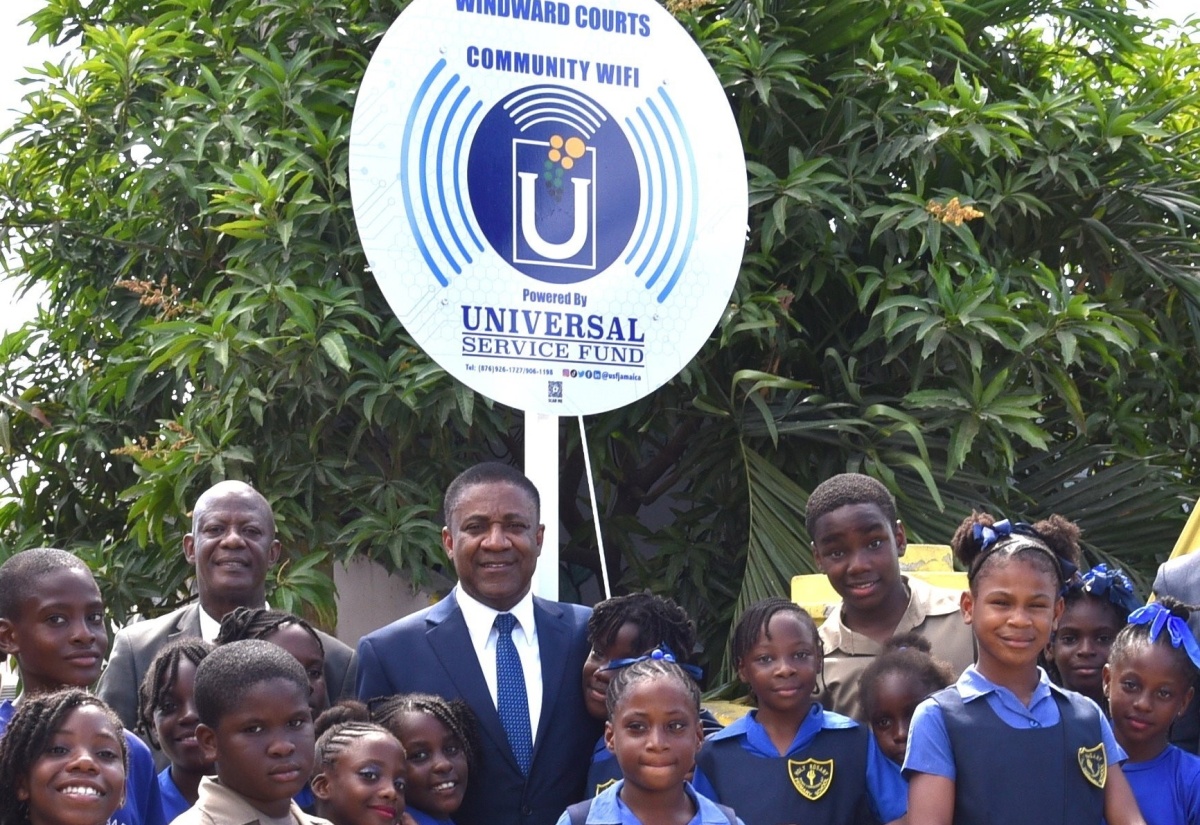 Chief Executive Officer of the Universal Service Fund (USF), Dr. Daniel Dawes (fourth left), and Kingston Eastern and Port Royal Member of Parliament, Phillip Paulwell, are surrounded by students from Holy Rosary Primary School, at the launch of community Wi-Fi at Windward Courts (Bower Bank), Kingston, on January 15.