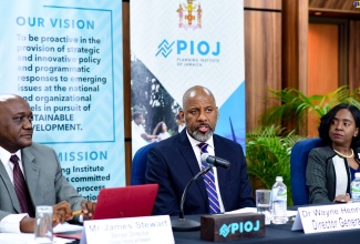 Director General, Planning Institute of Jamaica (PIOJ), Dr. Wayne Henry (centre), addresses the agency’s quarterly media briefing on Wednesday (February 21) at the PIOJ’s head office in New Kingston. With him (from left) are PIOJ Senior Director, Economic Planning and Research Division, James Stewart; and PIOJ Economic Specialist in the Growth Inducement Programme, Kellie-Ann Murray