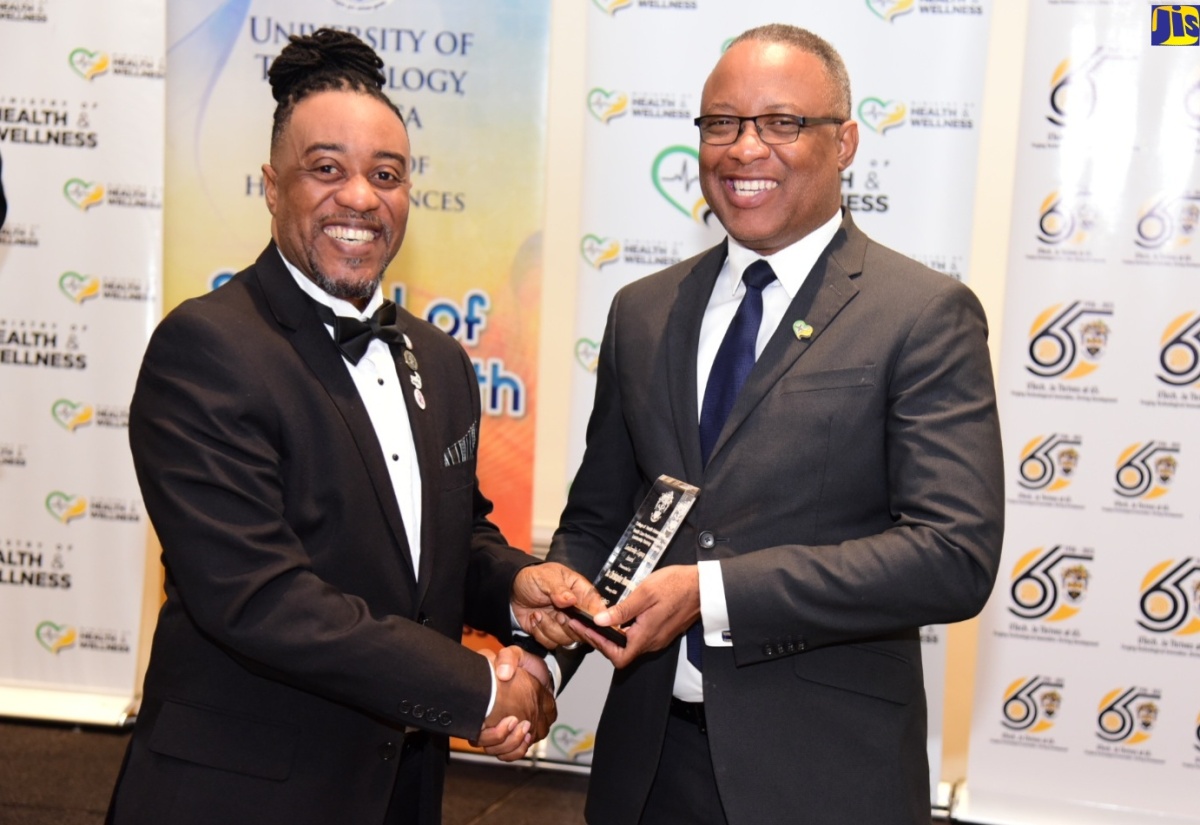 Permanent Secretary in the Ministry of Health and Wellness, Dunstan Bryan (right), presents the Outstanding Performer Award to Chief Executive Officer, St. Joseph’s Hospital, Dr. Christopher Munroe, during a recent graduation ceremony for 39 public health personnel who participated in a Healthcare Administration and Leadership certification course at the University of Technology (UTech). The ceremony was held at The Jamaica Pegasus hotel in New Kingston.

