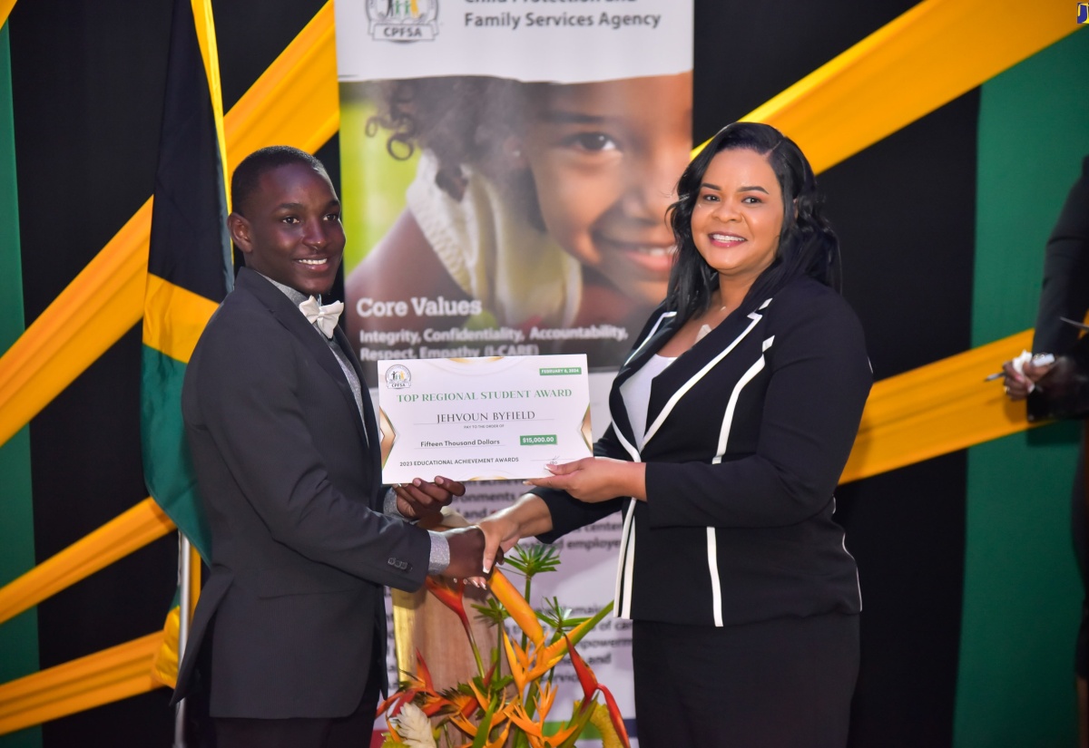 Chief Executive Officer of the Child Protection and Family Services Agency (CPFSA), Laurette Adams-Thomas (right), presents Jehvoun Byfield with the Top Regional Student Award for the CPFSA’s Southeast Region. Occasion was the CPFSA’s Educational Achievement Awards held on February 8 at the Terra Nova All-Suite Hotel in St. Andrew.


