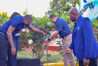 Prime Minister, the Most Hon. Andrew Holness (second right), and Minister without Portfolio in the Office of the Prime Minister with Responsibility for Information and Member of Parliament for Clarendon North Central, Hon. Robert Morgan (left), officialy turn on the $30 million expanded Mocho Water Supply System in Eden, Clarendon, on Friday (February 2). Looking on is National Water Commission (NWC) Regional Manager, Gawaine Johnson.

