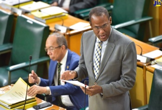 Minister of Finance and the Public Service, Dr. the Hon. Nigel Clarke, tables the Estimates of Expenditure in the House of Representatives on Thursday (February 15). At left is Minister of National Security, Hon. Dr. Horace Chang.