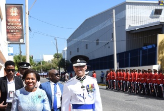 Wife of the Governor-General, Her Excellency the Most Hon. Lady Allen (left), is escorted into Gordon House for the ceremonial opening of Parliament on Thursday (February 15), by Commissioner of Police, Major General Antony Anderson.