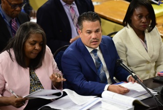 Minister without Portfolio in the Ministry of Economic Growth and Job Creation, Senator the Hon. Matthew Samuda (centre), responds to questions posed during today’s (March 6) sitting of the Standing Finance Committee of the House of Representatives. With the Minister are (from left) Chairperson for the Oversight Committee of the New Social Housing Programme, Judith Robb Walters and Permanent Secretary in the Ministry, Arlene Williams.

