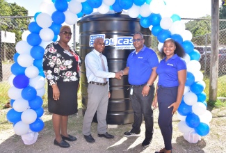 Principal of Windsor Castle All-Age School, Robert Watson (second left), shakes hands with Courts Ready Cash Marketing Officer (Events), Carlos Wright, following the presentation of a water tank (pictured in the background) to the institution. The presentation was made during the official handover ceremony at the school in Windsor Castle, Portland on Thursday (February 29). Sharing the moment are (from left) Senior Education Officer in the Ministry of Education and Youth, Tanya Sinclair; and teacher, Windsor Castle All-Age Infant Department, Ann Marie Roulston. The donation formed part of Courts Ready Cash’s islandwide water tank intitative. Under the venture, water tanks are donated to selected primary and secondary schools in the parishes of Clarendon, St. Thomas, Portland, St. Mary, St. Catherine and Hanover.


