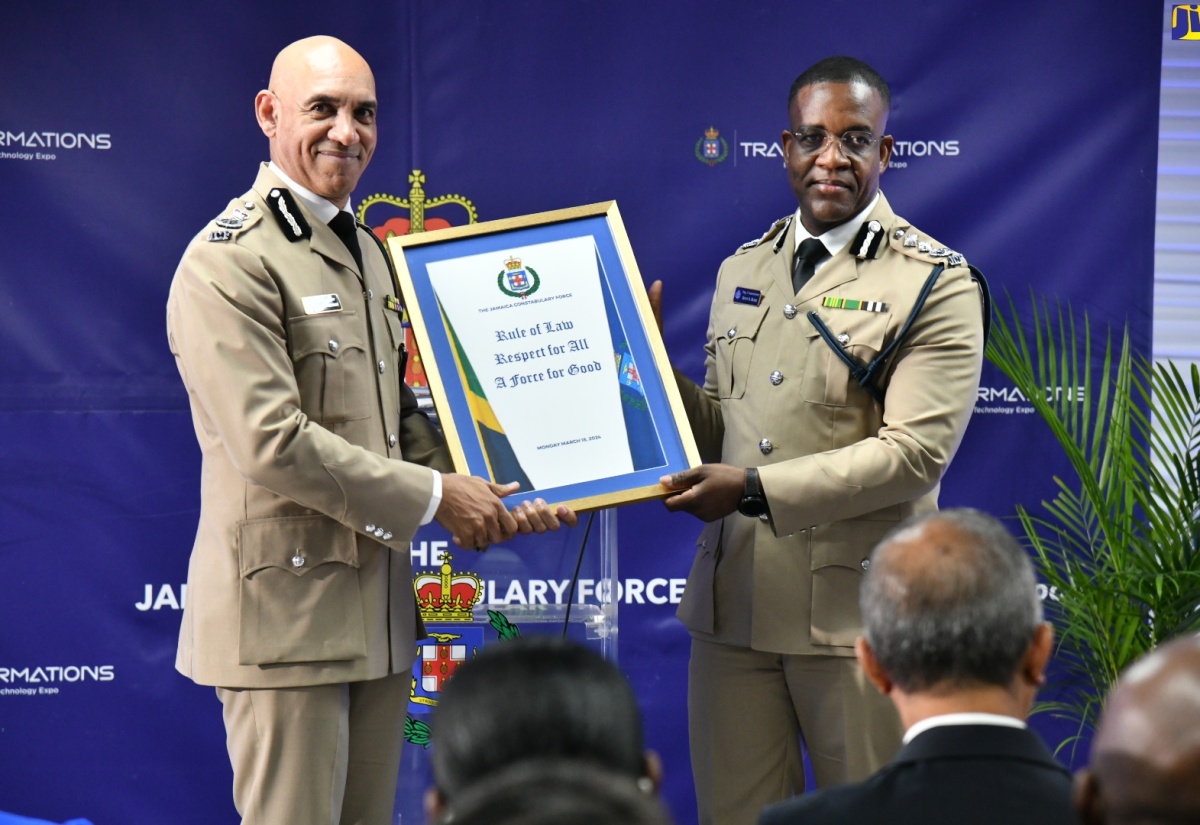 New Commissioner of Police, Dr. Kevin Blake (right), receives a framed replica of the Jamaica Constabulary Force’s core values from Outgoing Commissioner of Police, Major General Antony Anderson, at the  Change of Command ceremony, held at the Office of the Police Commissioner, located at 101-105 Old Hope Road, in St. Andrew, on March 18.

