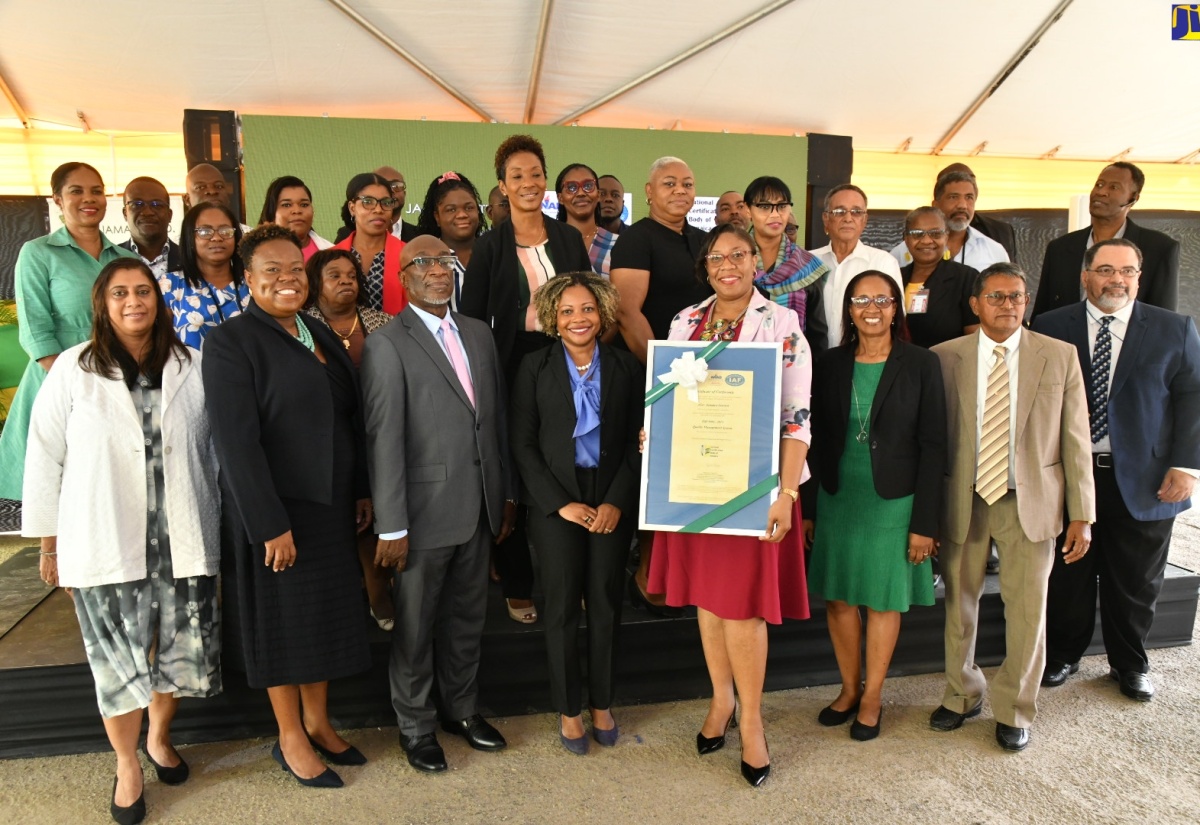 Minister without Portfolio in the Office of the Prime Minister, with responsibility for Skills and Digital Transformation, Senator Dr. the Hon. Dana Morris Dixon (fourth left, front row), and acting Chief Executive Officer, eGov Jamaica Limited, Anika Shuttleworth (fourth right, front row), share a photo opportunity with employees and participants attending the entity’s ISO 9001:2015 certificate handover ceremony. The event was held at eGov’s Old Hope Road offices in Kingston on Tuesday (March 19)