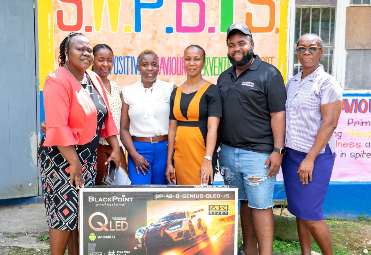 Dermaine Sinclair of Cecil Auto Services Limited, hands over a television set to staff of the Chantilly Primary and Infant School (from left), Jayann Lee, Zasanya Rowe, Juleen Morrison, and Principal, Nicole Poyser. The television was among technology devices and school supplies donated by the business to the Westmoreland-based institution recently.