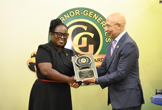 Governor-General, His Excellency the Most Hon. Sir Patrick Allen, presents recipient of the 2023 Governor-General Achievement Award (GGAA), Alethia Peart, with her plaque on June 29, 2023.