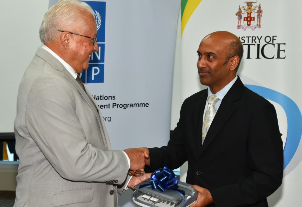 Minister of Justice, Hon Delroy Chuck (left), is presented with a stenography machine by Resident Representative, United Nations Development Programme (UNDP), Kishan Khoday. Occasion was the recent handover of stenography devices and laptops valued at more than $30 million by the Government of Canada through the Social Justice Project (SO-JUST) to the Court Administration Division and the Justice Training Institute, at the University of the West Indies (UWI) Regional Headquarters in Mona, St. Andrew.