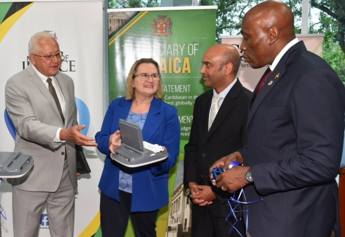 Minister of Justice, Hon. Delroy Chuck (left), joins High Commissioner for Canada to Jamaica, Her Excellency Emina Tudakovic; United Nations Development Programme (UNDP) Resident Representative, Kishan Khoday (second right); and Chief Justice, Hon. Bryan Sykes, at a ceremony for the handover of stenography machines and laptops to the justice system, held at the University of the West Indies (UWI) Regional Headquarters in Mona, St. Andrew on Friday (March 1). The items, valued at $30 million, were provided by the Government of Canada under the Social Justice Project (SO-JUST), which is being implemented by the UNDP.

