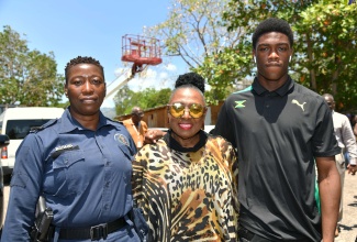 Minister of Culture, Gender, Entertainment and Sport, Hon. Olivia Grange (centre), is flanked by athlete, Shaquane Gordon (right) and his mother, Dukelyn Barrett, during a CARIFTA team send-off at the Jamaica Amateur Athletics Association (JAAA) in Kingston on Thursday (March 28).

 