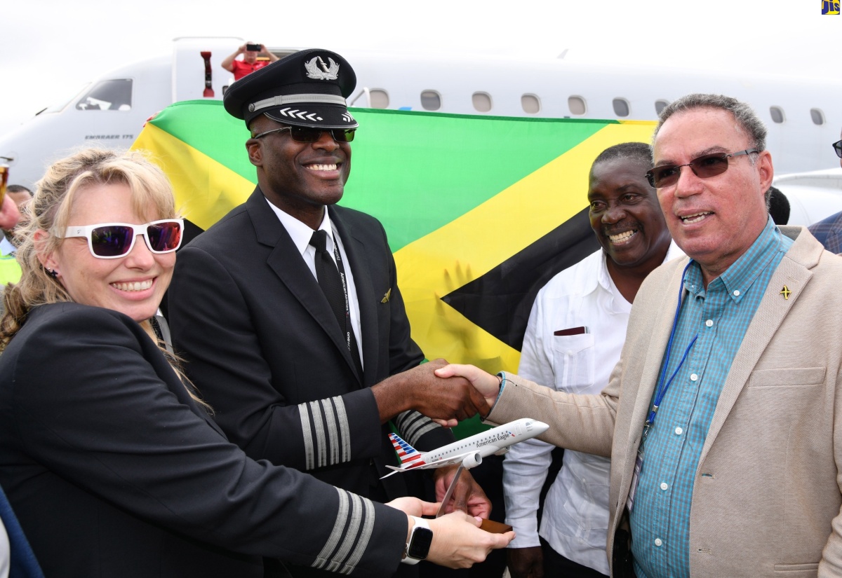 Minister of Science, Energy, Telecommunications and Transport, Hon. Daryl Vaz (right), receives a replica of an American Airlines (AA) aircraft from Jamaican-born pilot Captain Marc Coley (second left), who was in charge of the airline’s inaugural flight into the Ian Fleming International Airport in St. Mary on February 24. Sharing the moment is First Officer, Christy Schafer (left), while Member of Parliament for St. Mary Western, Robert Montague (second left), looks on.

