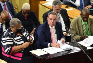 Minister of Science, Energy, Telecommunications and Transport, Hon. Daryl Vaz (centre), addresses the Standing Finance Committee in the House of Representatives on March 5. The Minister is flanked by Permanent Secretary in the Ministry, Carol Palmer (left) and State Minister, Hon. J.C. Hutchinson (right). 