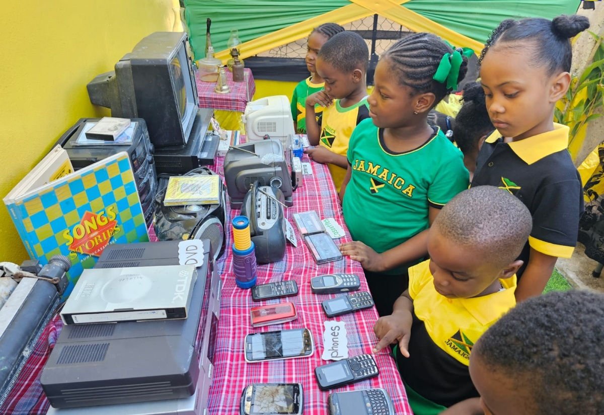 Students of the Unity Basic School look at old electronic items on display at the Jamaica Day Exhibition at the institution in St. Catherine on Friday (March 1). The items included a DVD player, antenna radios and televisions, vintage desktop computers, typewriters and cassette players. 