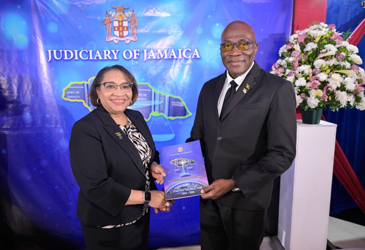 Chief Justice, the Hon. Bryan Sykes (right), presents Permanent Secretary in the Ministry of Justice, Grace Ann Stewart McFarlane, with the Judiciary of Jamaica’s 2024 to 2028 Strategic Business Plan. Occasion was the launch of the document on April 10 at the Terra Nova All-Suite Hotel in St. Andrew.