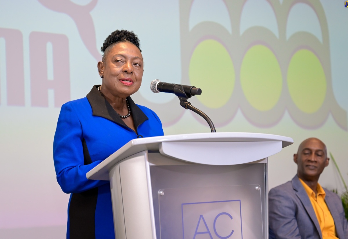 Minister of Culture, Gender, Entertainment and Sport, Hon. Olivia Grange, addresses the launch of the Jamaica Athletics Administrative Association (JAAA) Jamaica Athletics Invitational track meet during a press briefing at the AC Hotel by Marriott Kingston on Thursday (April 11). Seated is JAAA President, Garth Gayle.
