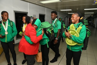 Minister of Culture, Gender, Entertainment and Sport, Hon. Olivia Grange (second left), warmly greets members of Jamaica’s victorious CARIFTA Games team on their arrival at the Norman Manley International Airport in Kingston on April 2. The team claimed Jamaica’s 38th straight CARIFTA games title, winning a total of 84 medals at the games held in Grenada from March 30 to April 1.

