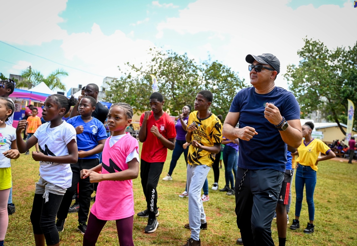 Minister of Health and Wellness, Dr. the Hon. Christopher Tufton, goes through several exercise routines with students participating in Friday’s (April 26) National School Moves Day event at Manchester High School in Mandeville.

