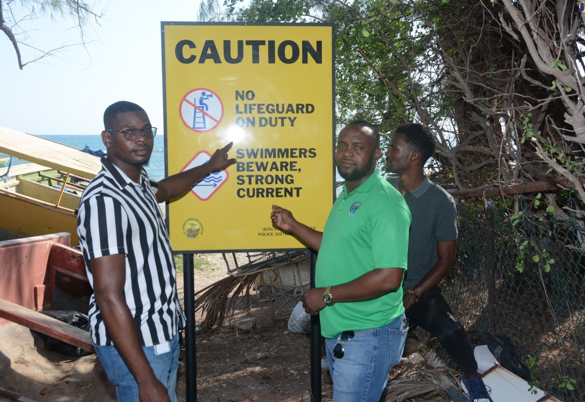 Director of Product Quality and Community Tourism at Tourism Product Development Company Limited (TPDCo), Lionel Myrie (centre), is joined by TPDCo’s Community Tourism Manager, Desmond Saunders (left), and TPDCo’s Public Relations Officer, Vaughn Thorpe, in highlighting one of the 18 signs erected along the Treasure Beach coastline in St. Elizabeth, on Friday (April 5).

