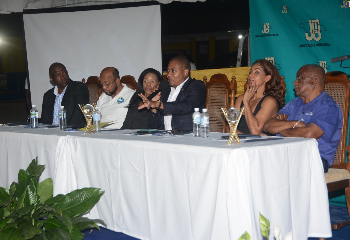 Minister of Agriculture, Fisheries and Mining, Hon. Floyd Green (fourth left), fielding questions during the question-and-answer session of a town hall meeting organised by the Ministry and Jamaica Bauxite Mining Limited (JBM), at Golden Grove All-Age School in St. Ann, on April 19. He is joined by (from left) Managing Director of GDM Associates, Gawayne Murdock; Mayor of St. Ann's Bay, Councillor, Michael Belnavis; JBM Managing Director, Donna Marie Howe; Member of Parliament for St. Ann South Eastern Lisa Hanna; and Minister of State in the Ministry of Agriculture, Fisheries and Mining, Hon. Franklin Witter.

