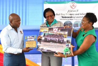 Minister of Labour and Social Security, Hon. Pearnel Charles Jr. (left) and Director, Social Security in the Ministry, Suzette Morris (centre), receive gifts from Board Chair, Bull Bay Primary and Infant School, Jodi Bernard Kerr (right). Occasion was a visit to the institution in St. Thomas on Friday (April 19), to participate in the school’s rebranding project. The Ministry has played a key role in the rebranding by instituting a uniform project to benefit all students.

