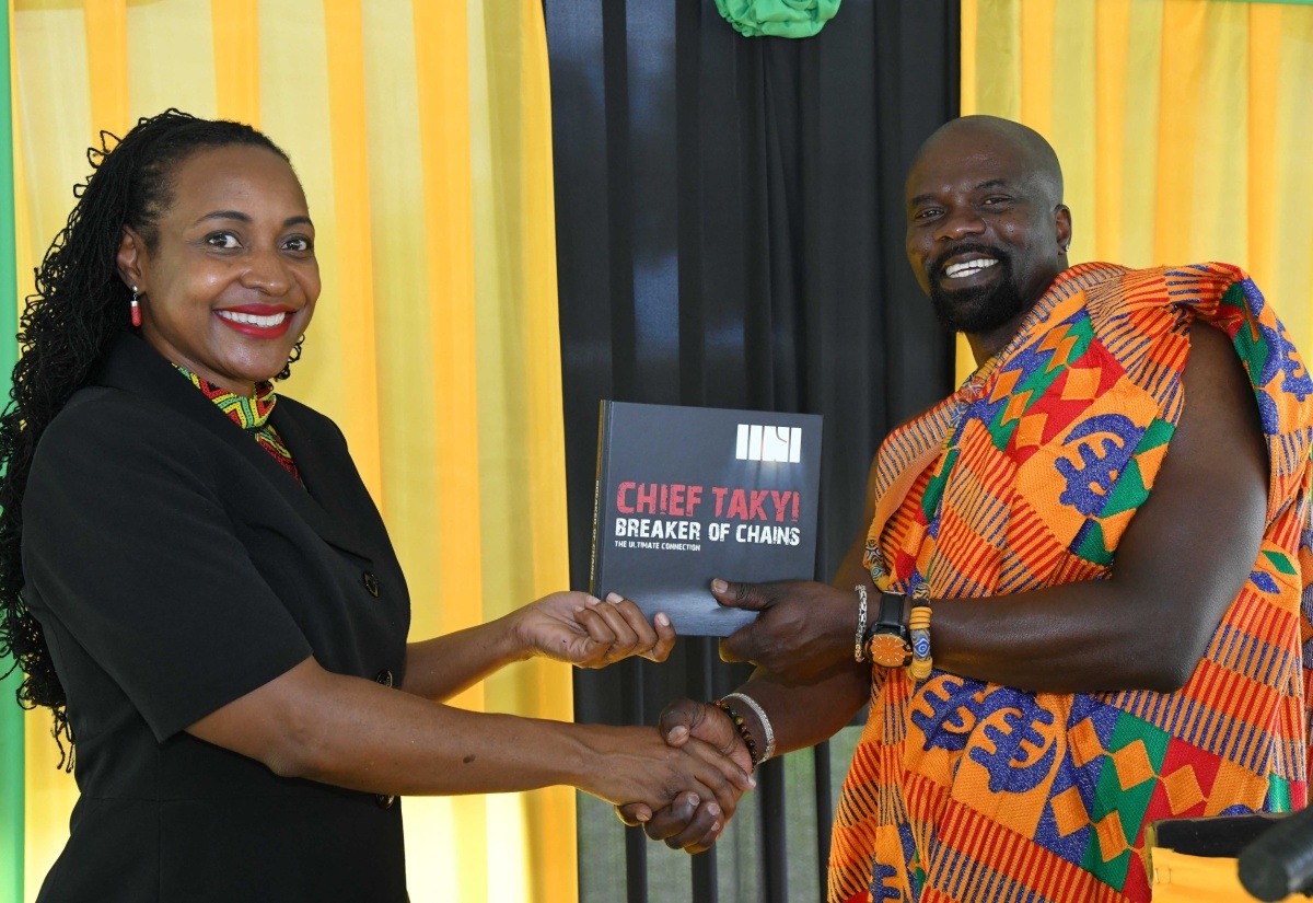 Minister of State in the Ministry of Education and Youth, Hon. Marsha Smith, receives a copy of 'Chief Takyi – Breaker of Chains' from author, Enoch Takyi, during the third Annual Tacky Day celebrations at the St. Mary Parish Library in Port Maria on Monday (April 8). The event was held to honour the courageous acts of Chief Takyi [Tacky], who led the 1760 slave rebellion in Jamaica.