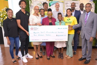 Minister of Culture, Gender, Entertainment and Sport, Hon. Olivia Grange (front, centre); is joined by Minister of Education and Youth, Hon. Fayval Williams (third left); and Minister of Finance and the Public Service, Dr. the Hon. Nigel Clarke (right), in presenting a $2-million grant, provided through the Sports Development Foundation (SDF),  to the Aquatic Sports Association of Jamaica at the Sport Ministry in New Kingston on March 20. General Manager of the SDF, Alan Beckford, is in the background, at centre. Sports associations will continue to benefit from support through the SDF in 2024/25.


